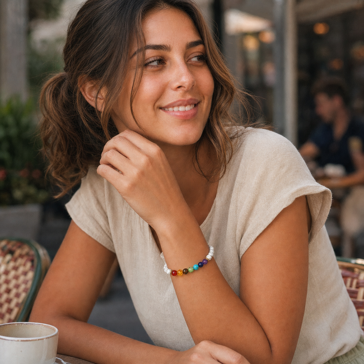 Lachendes Model mit weißem Chakra-Armband im Café