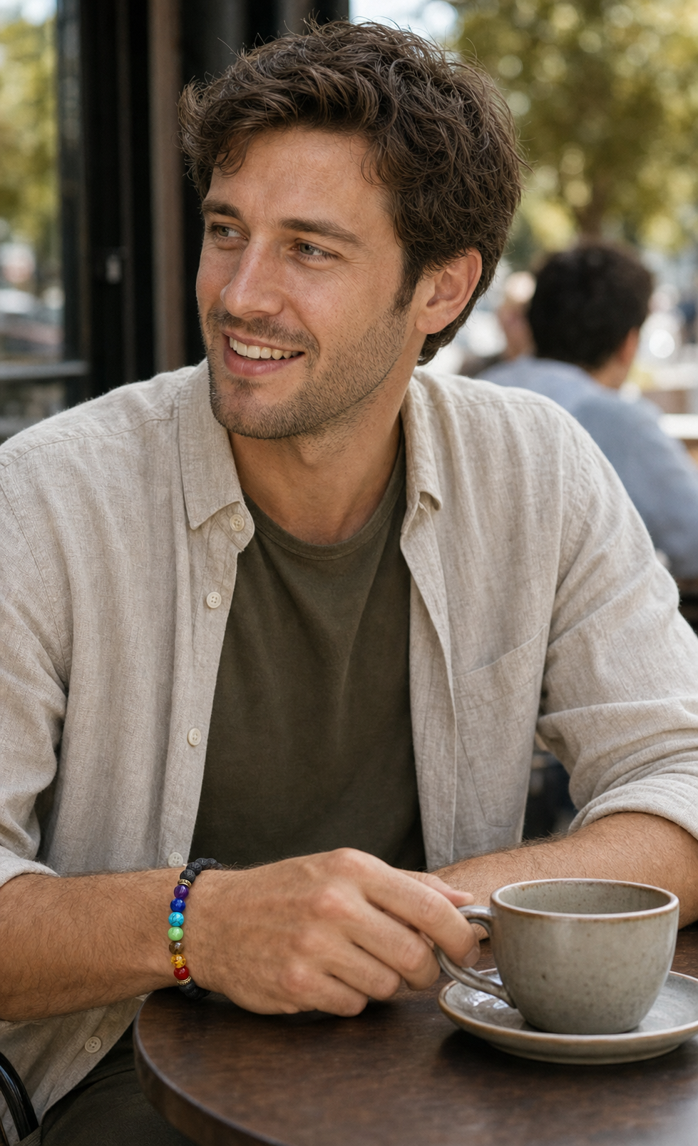 Mann trägt ein schwarzes Chakra-Armband in einem Café